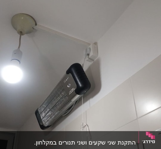 מנורה תלויה ותנור חימום חשמלי על הקיר